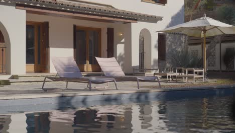 sillones junto a la piscina en un retiro de villa