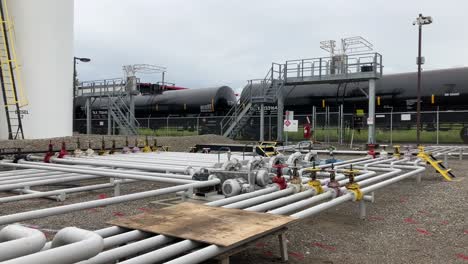 toma panorámica de un camión cisterna de combustible, tuberías de combustible y grandes contenedores