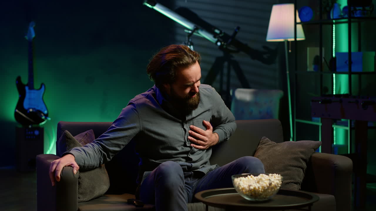 tv 를 보는 동안 심장마비 를 겪고 있는 아파트 에 앉아 있는 사람