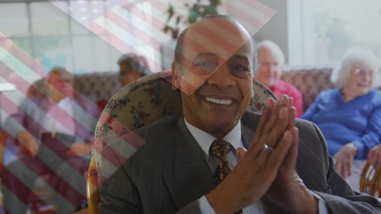 Animation of flag of usa over african american businessman and senior diverse people