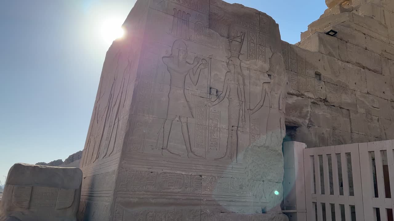 Dendera Tapınağı'nın arkeolojik alanında Mısır tanrılarının ve hiyerogliflerin detaylı kabartmalarını içeren büyük antik bir taş bloğun yakın çekimi.