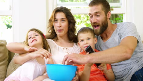 Familia-Comiendo-Palomitas-De-Maíz-En-Un-Sofá