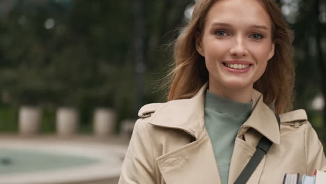 caucasian female student looking at the camera and smiling outdoors.