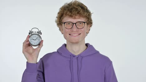 smiling redhead young man holding clock, white background