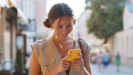 Lächelnde-Frau,-Die-Mit-Dem-Smartphone-Text-Tippt,-Nachrichten-Beantwortet-Und-Online-In-Der-Stadtstraße-Chattet