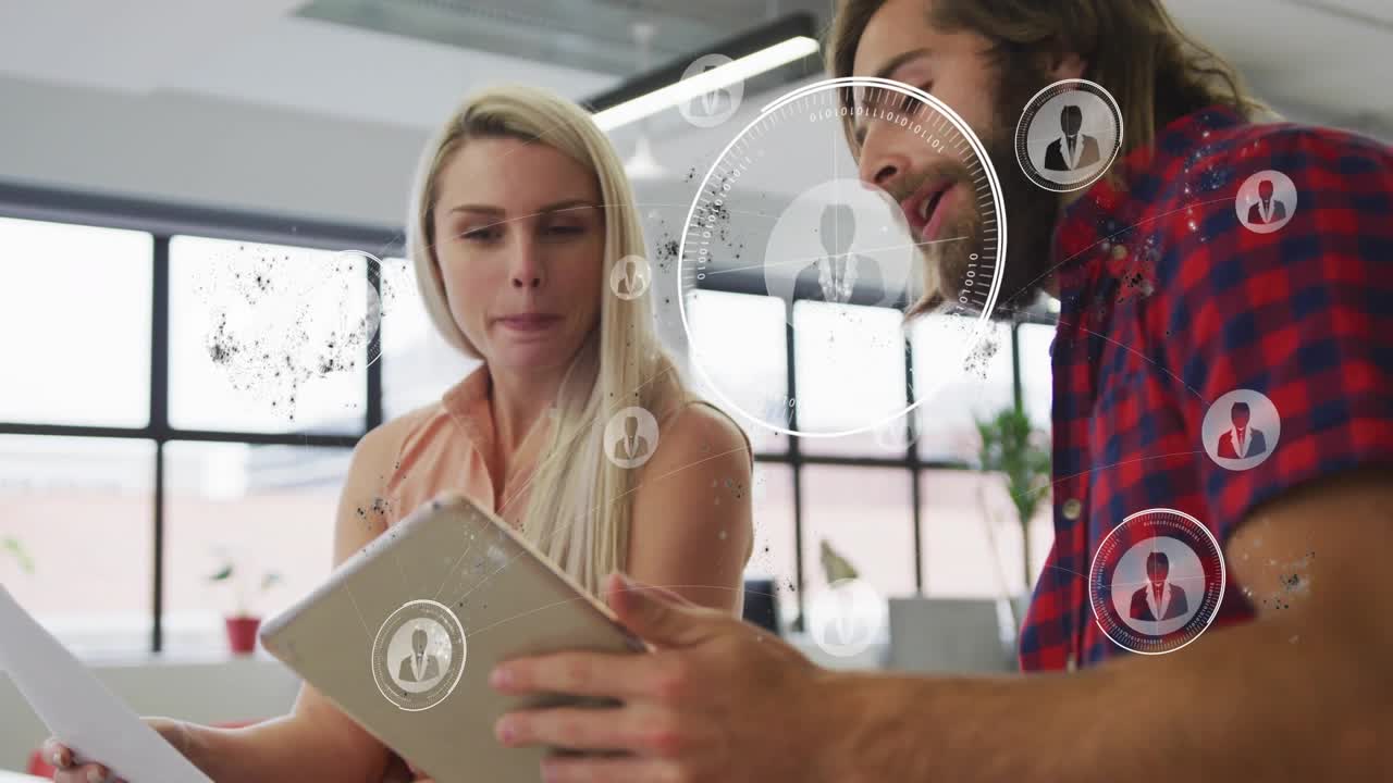 Colleagues leaning in reviewing tablet, man tapping screen and expanding HUD for business analysis