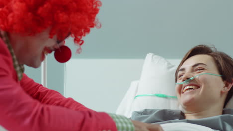 payaso del hospital haciendo reír a una joven paciente