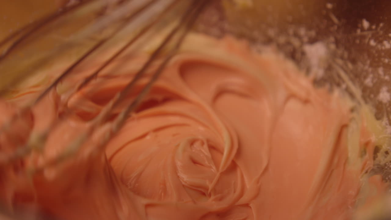Woman with light beige clothing and mixing pink frosting