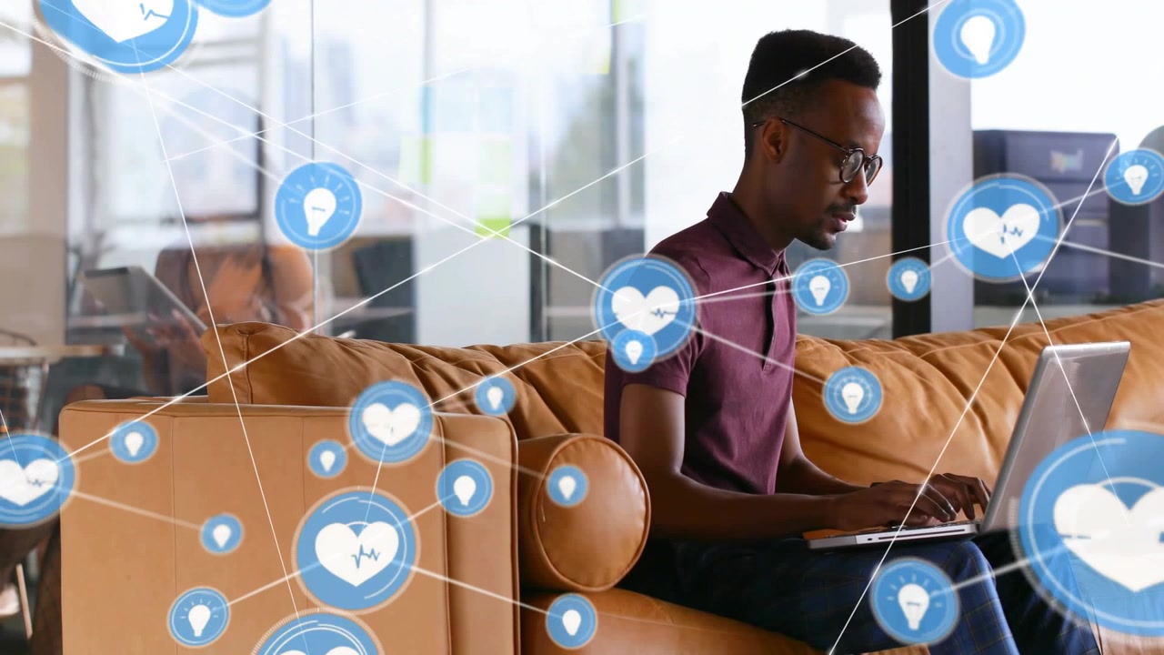 Vertical video: Man on sofa typing laptop, blue heart appearing and forming white lines health web