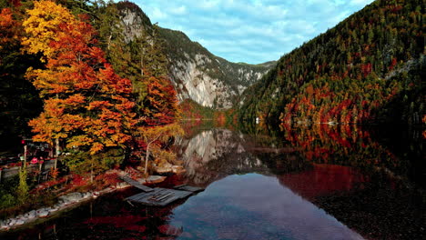 mirrored reflections of autumn forests and mountains on calm lake toplitz in austria