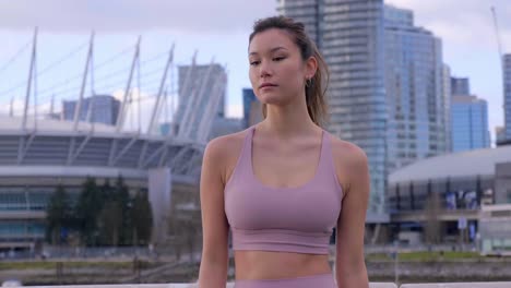 Asian-model-posing-in-building-landscape-of-downtown-Vancouver-BC,-Canada