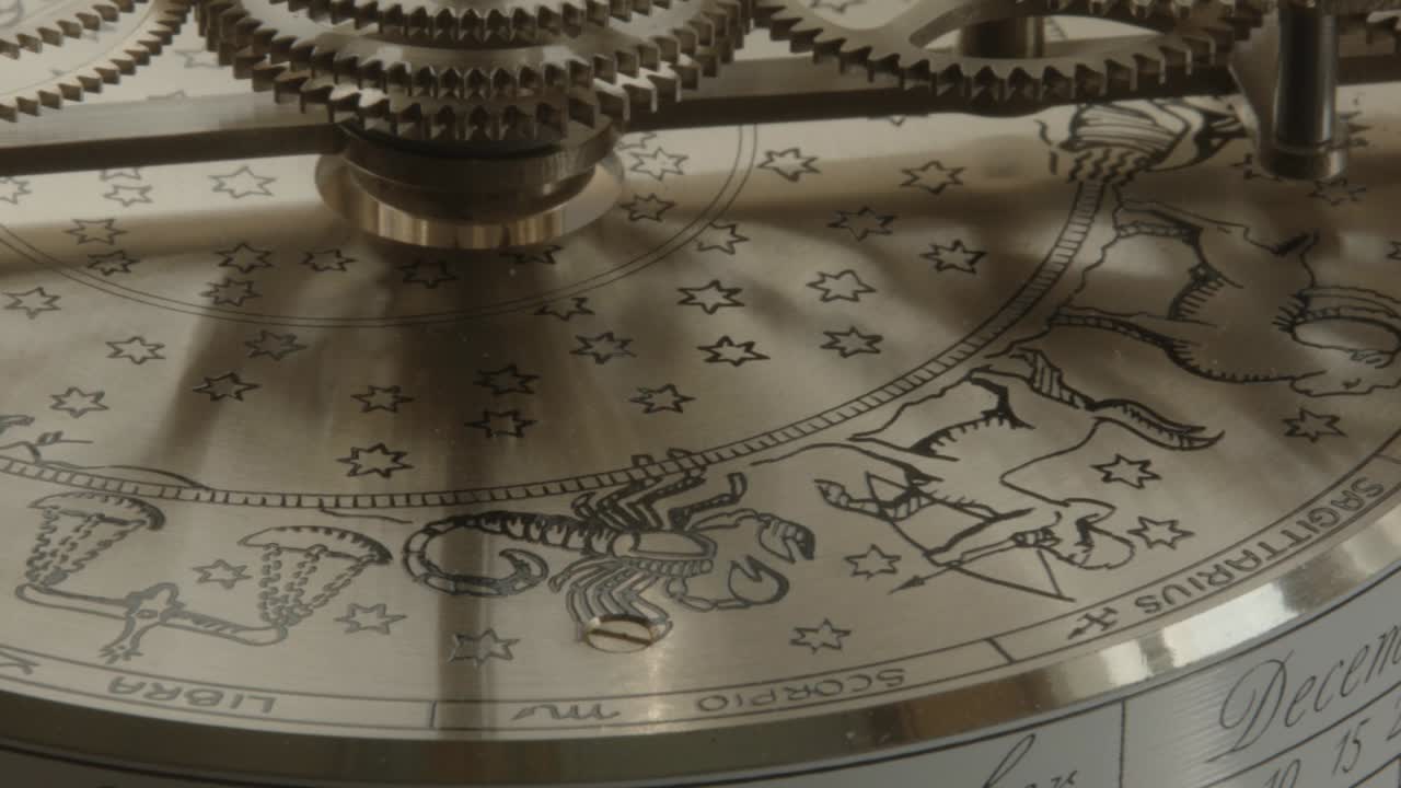 Slow pan from left to right of engraved Astrological Signs on a brass instrument