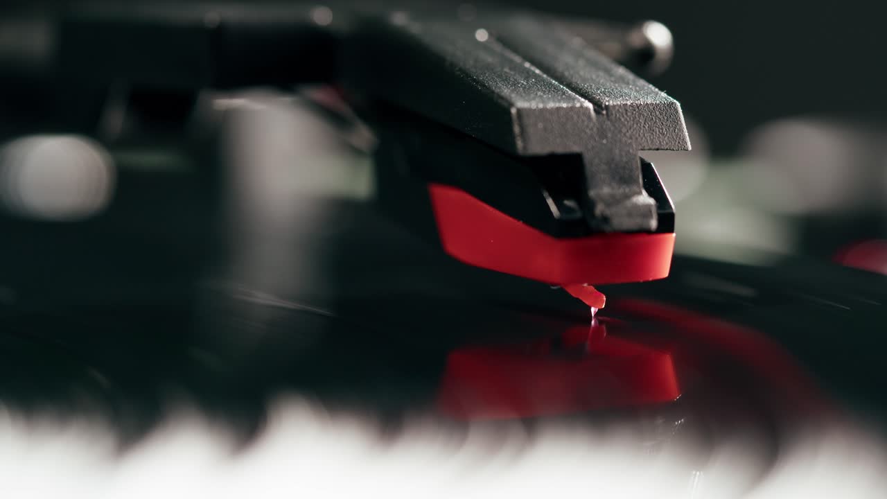 Red Stylus Playing Black Vinyl Record on Turntable