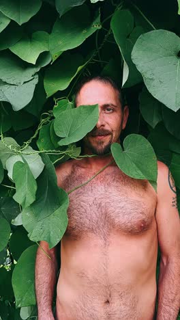 man hiding in green leaves