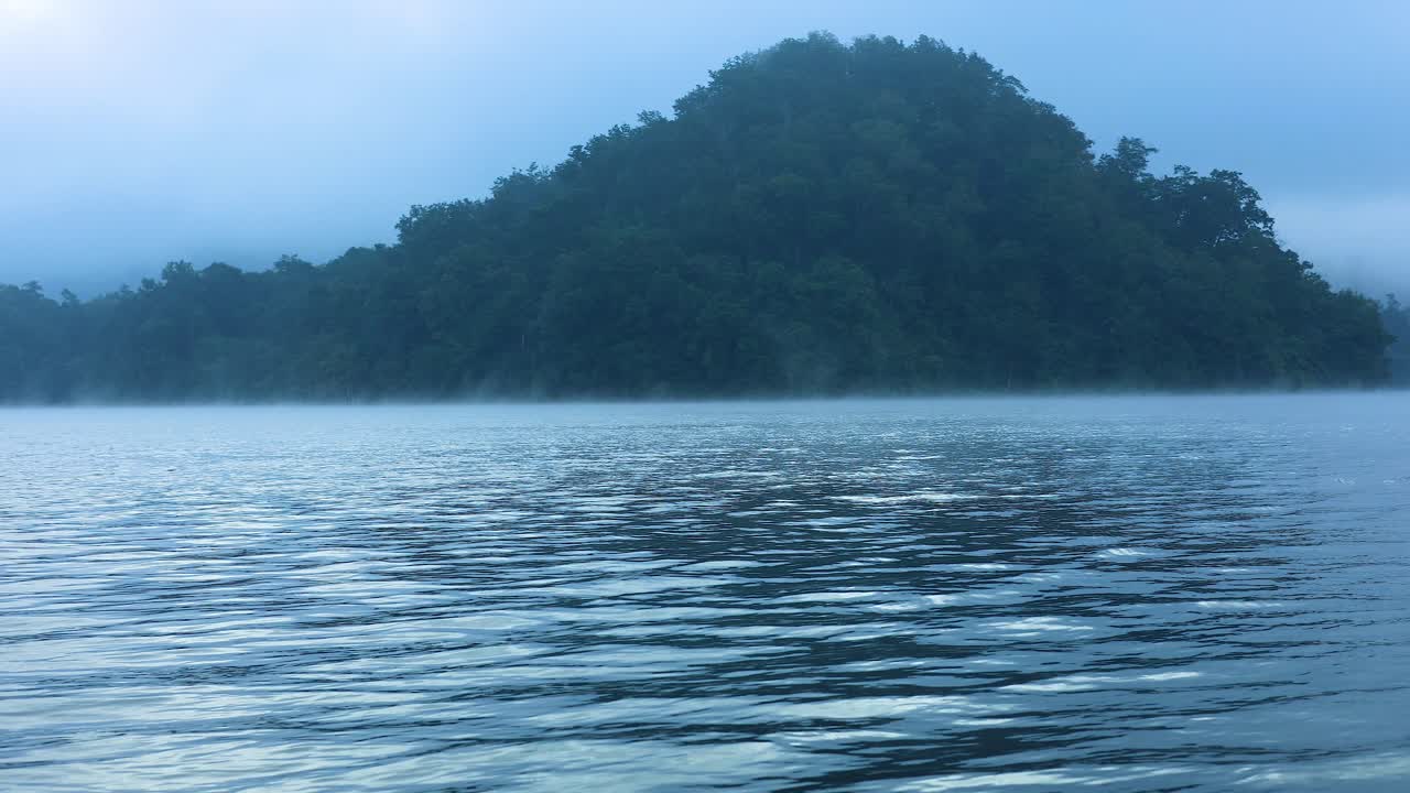 산 과 멀리 있는 구조물 들 이 있는 안개 가 가득 한 강 풍경