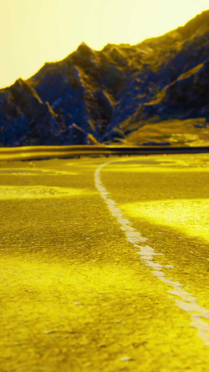 un camino sinuoso a través de un campo amarillo hacia las montañas