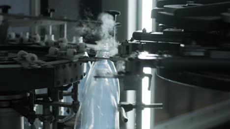 una máquina automática de llenado vierte agua en botellas de plástico en una moderna planta de bebidas