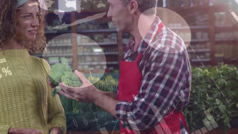 animation of data processing over happy caucasian male greengrocer talking to female customer