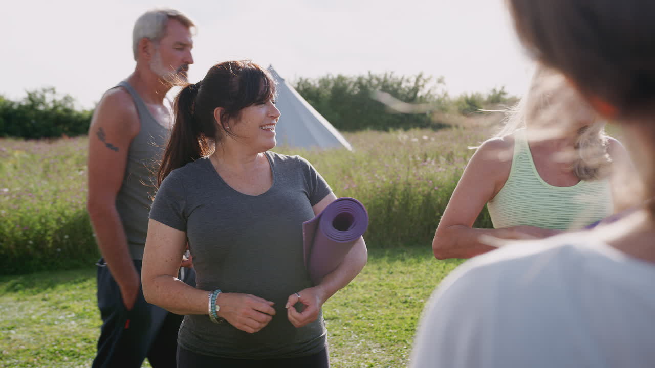 야외 요가 수업 에서 운동 매트 를 가진 성숙 한 남자 와 여자 들 의 그룹