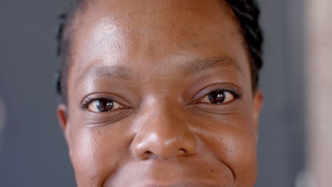smiling woman with braided hair looking directly at camera, close-up face shot