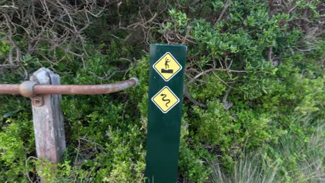 caution signs on a path near cliffs