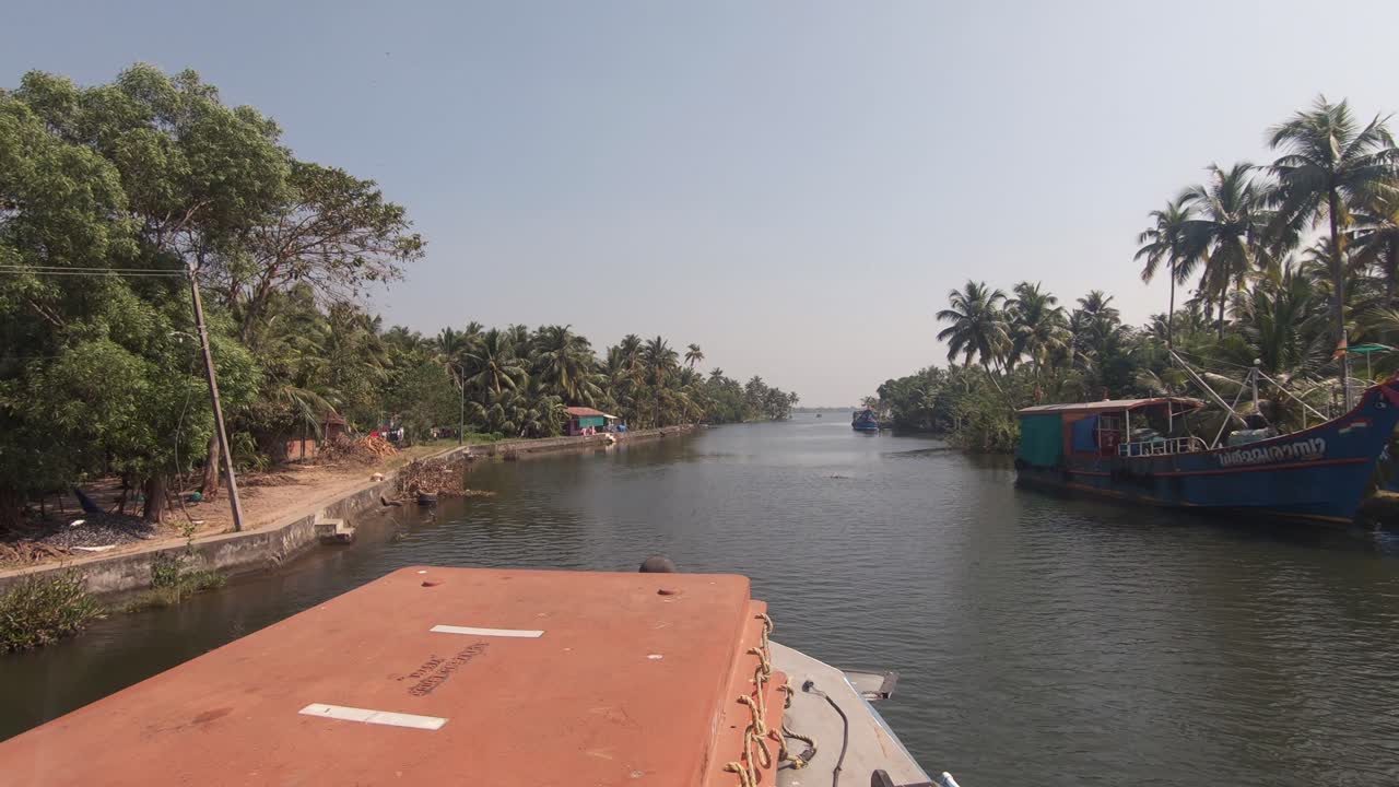 orillas del canal navegable de alappuzha o alleppey visto desde la proa del barco en movimiento, india