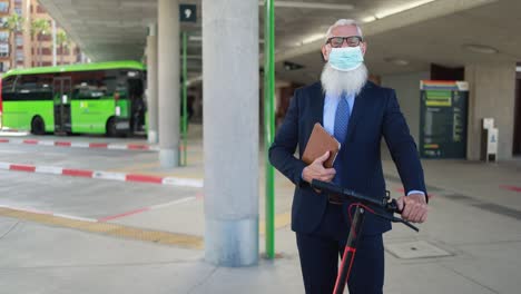 senior business man with electric push scooter in the city while wearing safety face mask for coronavirus outbreak