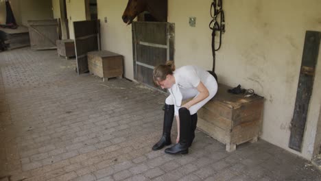 Caucasian-woman-putting-on-her-boots