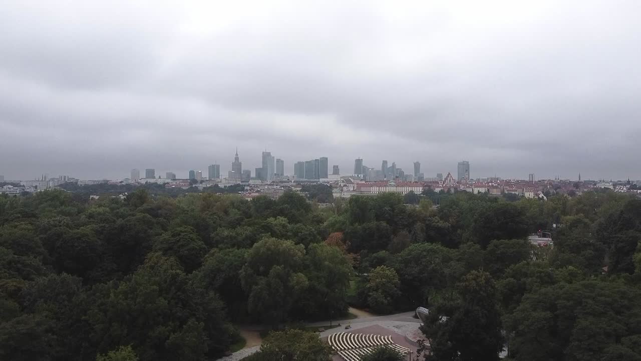 숲 앞 바르샤바 도시 스카이라인의 느린 드론 팬 영상