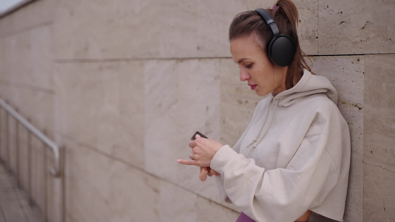 mujer escuchando música y usando el teléfono al aire libre