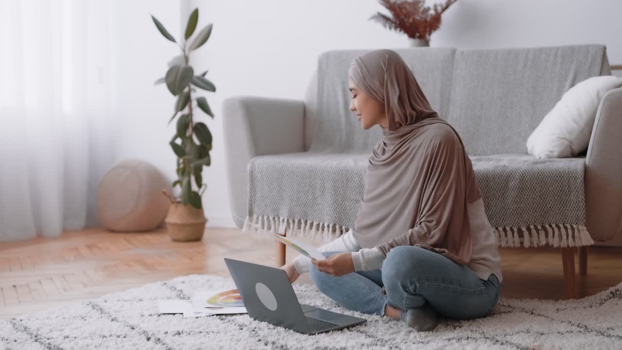 Woman in hijab studying design at home