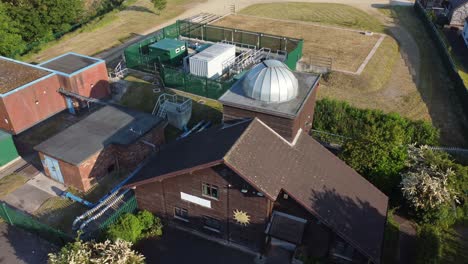 Absteigende-Luftaufnahme-Des-Pex-Hill-Leighton-Observatory,-Silberne-Kuppel-Auf-Dem-Dach-Eines-Ackerlandes-Auf-Einem-Hügel-Bei-Sonnenaufgang