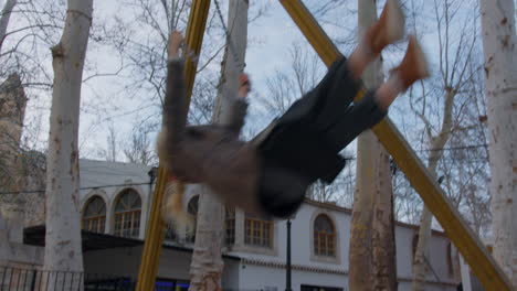 niño balanceándose en el patio de recreo