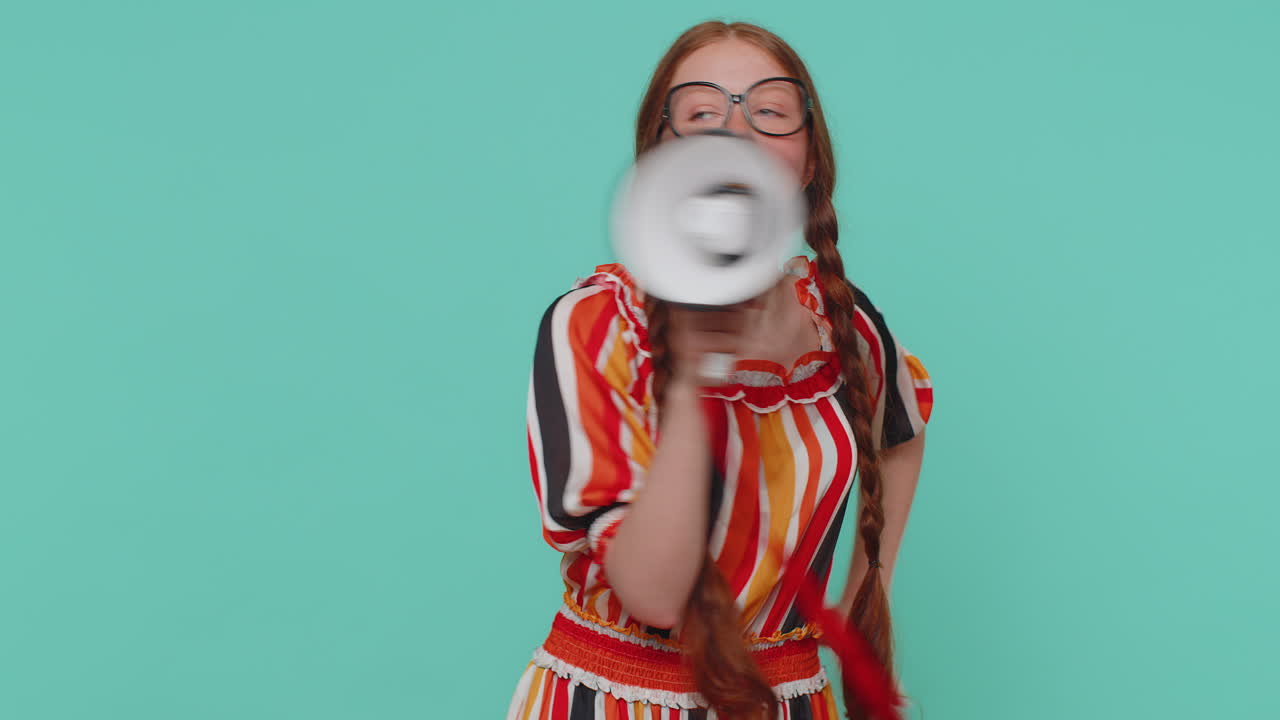 미소 짓는 홍색 소녀는 메가폰으로 이야기하고, 뉴스를 선포하고, 큰 소리로 판매 광고를 발표합니다.