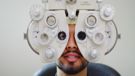 paciente masculino haciendo una prueba ocular con optometría