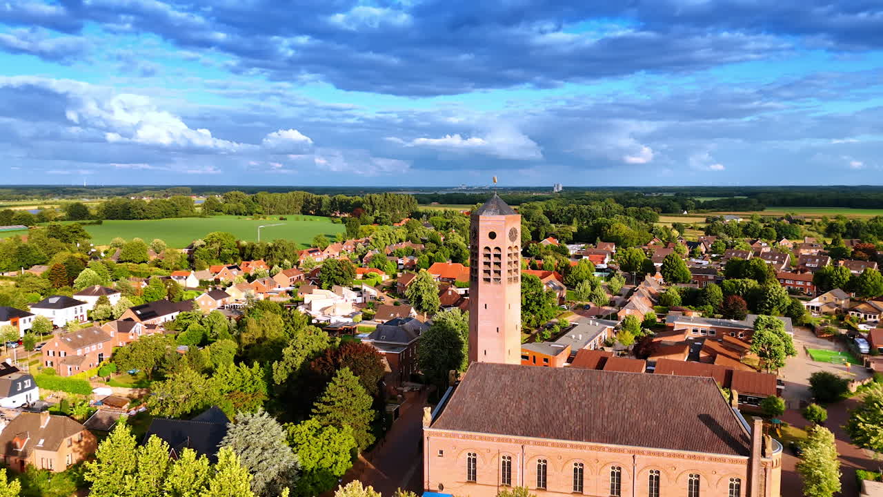 Flying closer to the Saint Lawrence Church with a freestanding clock tower. Picturesque sunny view of Vierlingsbeek, Netherlands