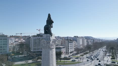 aerial, orbit, drone shot, towards marquês de pombal statue after quarantine time with first cars driving in lisbon city streets and liberty avenue in background, sunny day, in lisbon, portugal