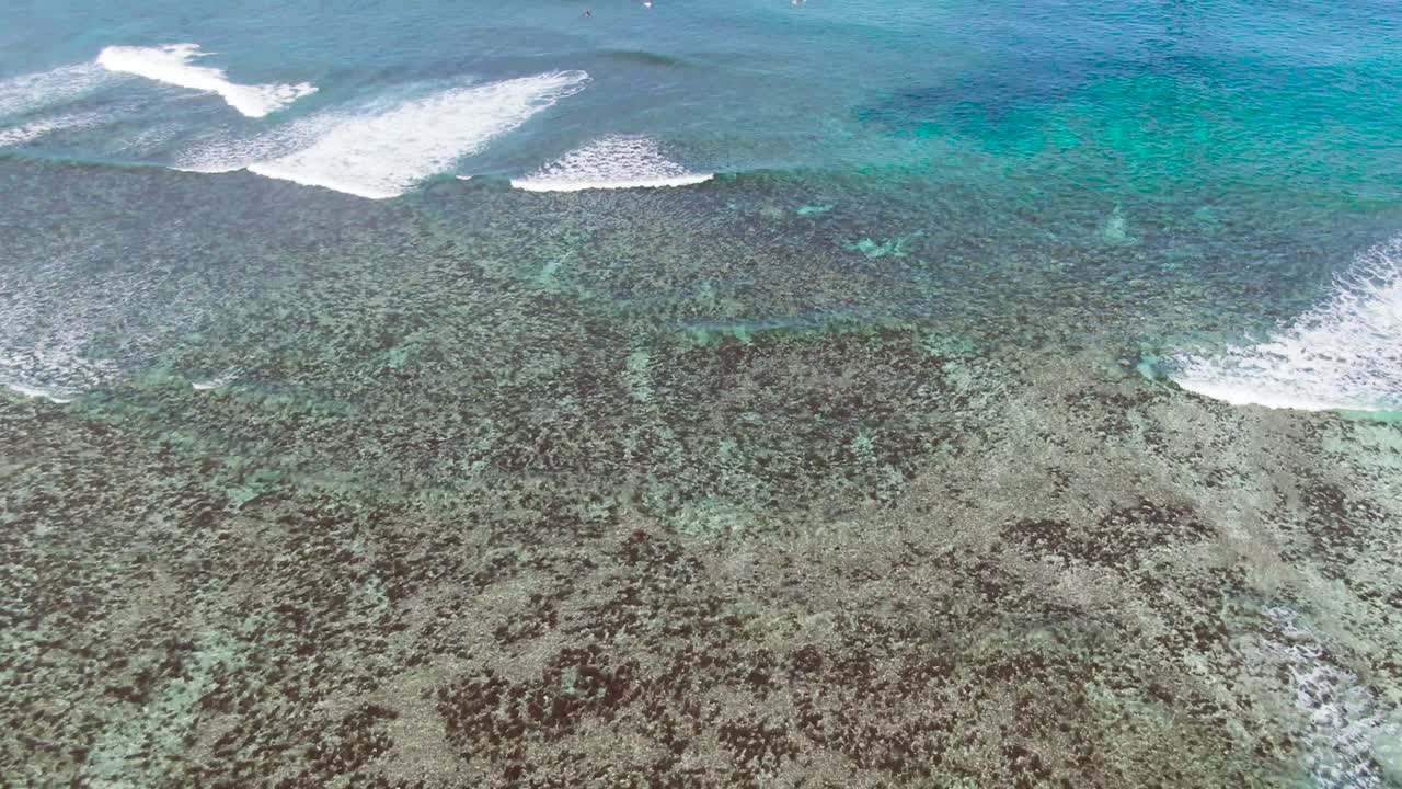 vista aérea de drones mirando hacia abajo a un gran paisaje oceánico con olas que se acercan lentamente hacia la orilla mirando hacia abajo a través del comedor cristalino hay vistas claras del lecho marino y la arena