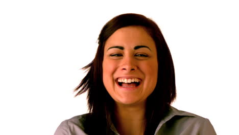 una morena feliz riendo sobre un fondo blanco