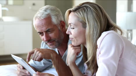 Couple-using-tablet-together-in-bed