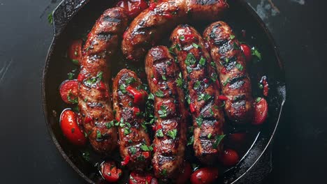 grilled sausages with cherry tomatoes in a cast iron skillet