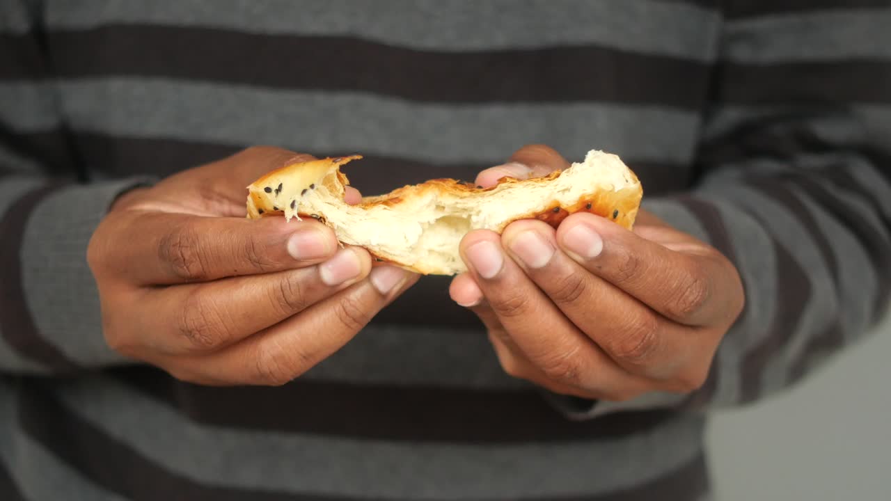 persona que sostiene un pan de semillas de sésamo