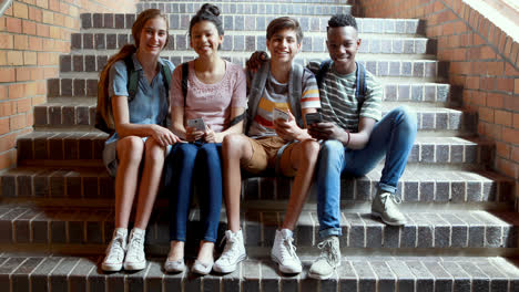 Klassenkameraden-Sitzen-Auf-Der-Treppe-Und-Benutzen-Mobiltelefone