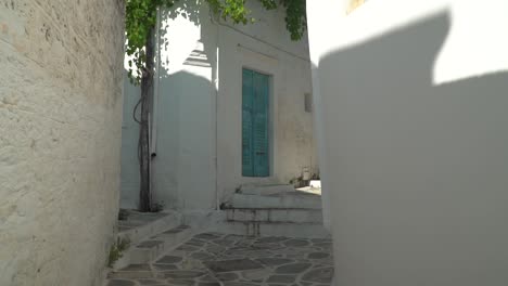 pov moving through narrow greek alley with typical blue doors and windows