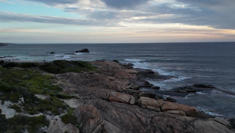 Aerial-orbiting-shot-showing-rocky-coastline-with-Indian-ocean-and-clouds-at-sunset---Western-Australia,-Red-Hate-Beach