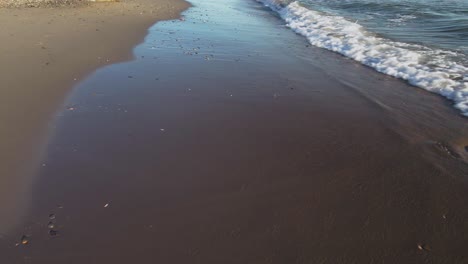 moviéndose a lo largo de la costa, las olas del océano salpicando en la playa