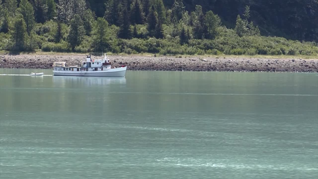 알래스카의 해안 가까이에서 항해하는 작은 보트