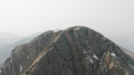 hikers standing atop smoky mountain summit - aerial 4k