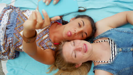 two friends taking a selfie on a blanket