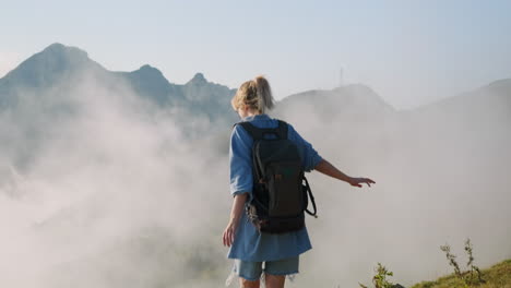 woman hiking through misty mountains